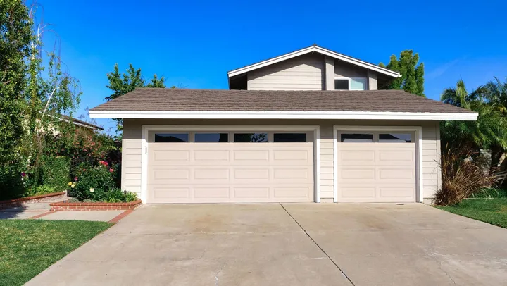 Single-story home with a white garage door under a clear blue sky in Phoenix, AZ