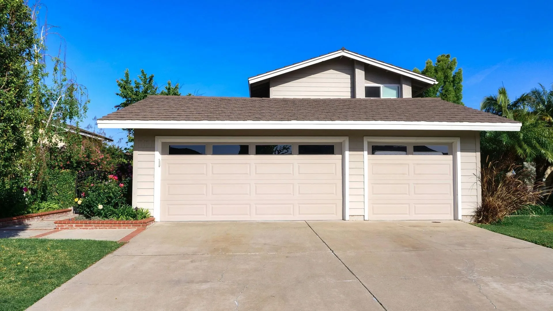 Two-story Chandler, AZ home with beige double and single garage doors on a wide concrete driveway