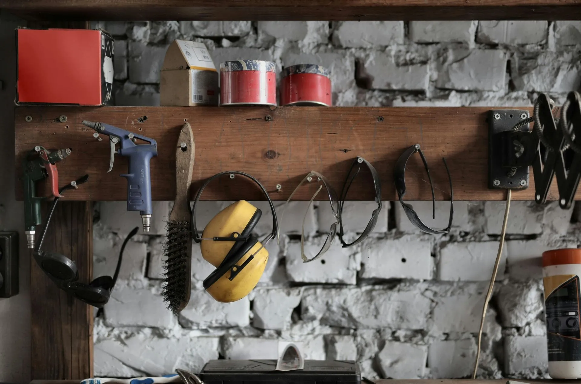 Safety glasses, ear defenders and hand tools racked in the shop we stock for Komatke garage door spring calls